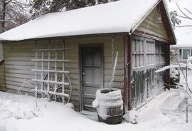 snow covered garage rain barrel