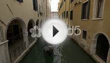 Paddling A Gondola By A Building With Arches In Venice
